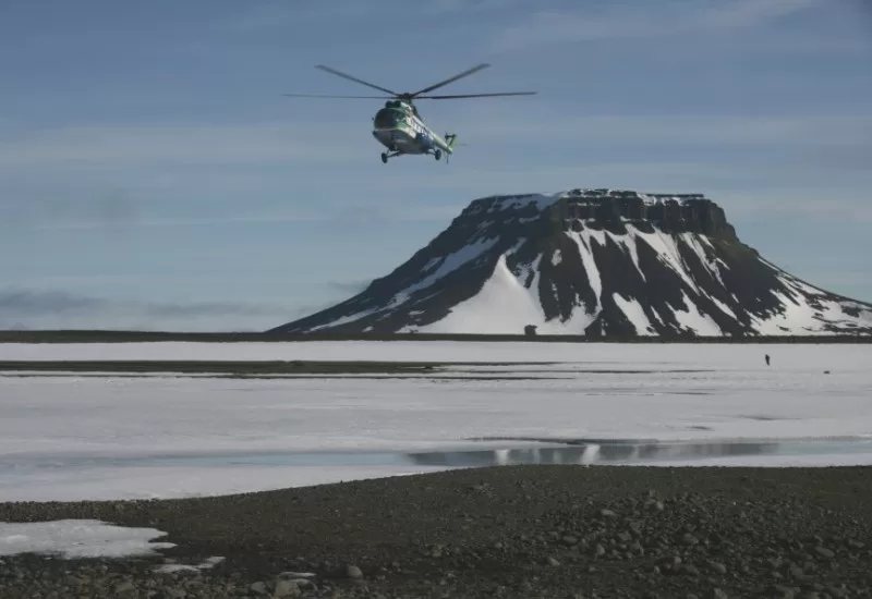 A helicopter flies above the North Pole