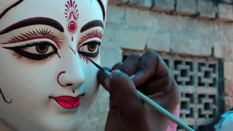 An artisan paints the eyes of Goddess Durga