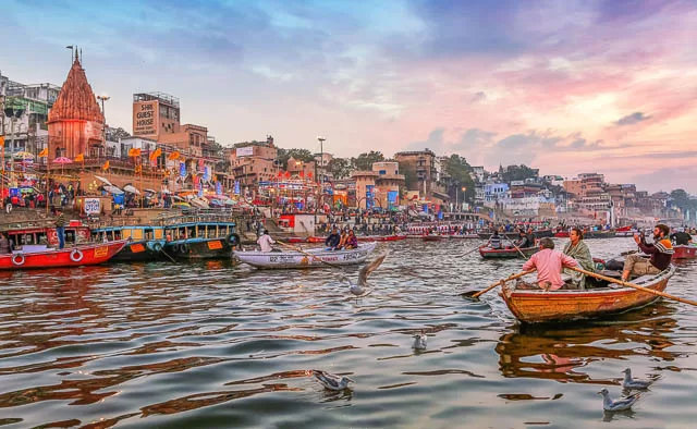 Dashaswamedh Ganges river ghat at twilight with tourists enjoying boating rides in Varanasi, Uttar Pradesh