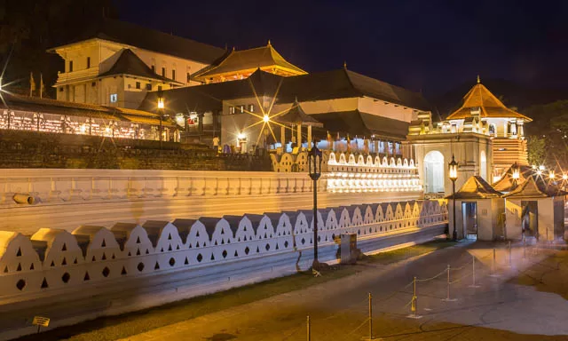 lights lit up at night in temple of the tooth in kandy, sri lanka