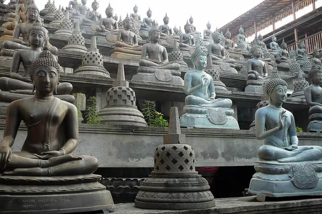 buddha statues lined up in gangaramaya buddhist temple in colombo, sri lanka