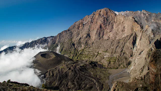 mount meru ash cone above clouds, arusha, tanzania