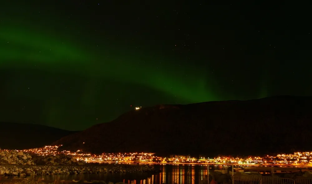 The aurora over the fjords and peaks around Tromsø.