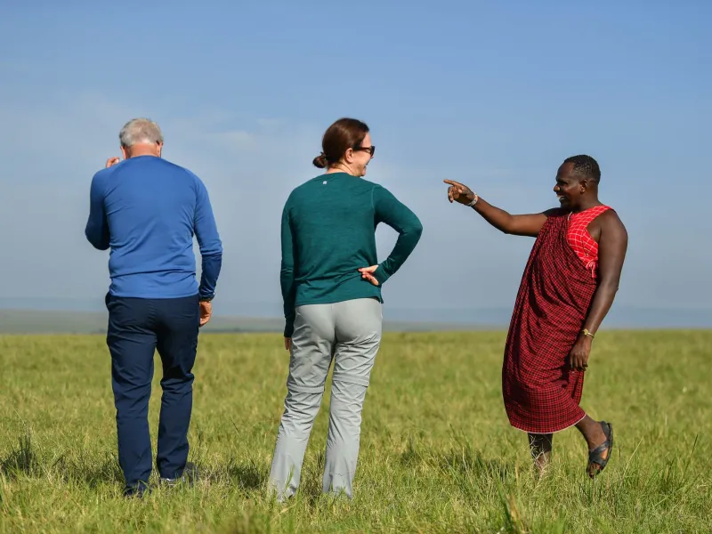 Guests on a guided walking safari on the open plains, armed guide leading.