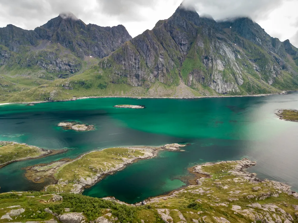 Red rorbuer cabins beneath the peaks at Hamnøy, Lofoten.